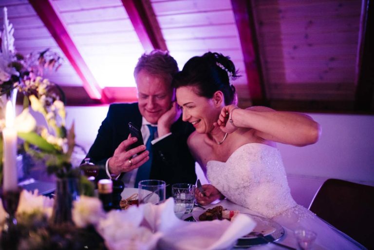 Brautpaar mit Handy beim Abendessen in der Winston Lounge, Hochzeitsplanung von Jessica Naujoks-Lehmann von FAIRY-TALE Weddings