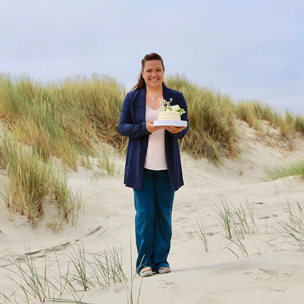 Hochzeitsplanerin Jessica Naujoks-Lehmann mit Hochzeitstorte in den Dünen von Juist, Hochzeitsplanung für die Insel Juist